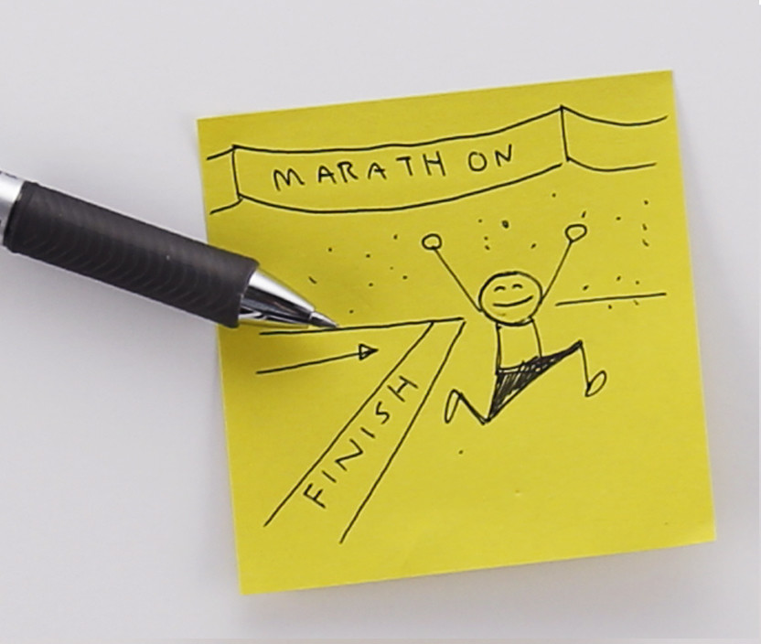 Post-it note with sketch of person crossing a finish line