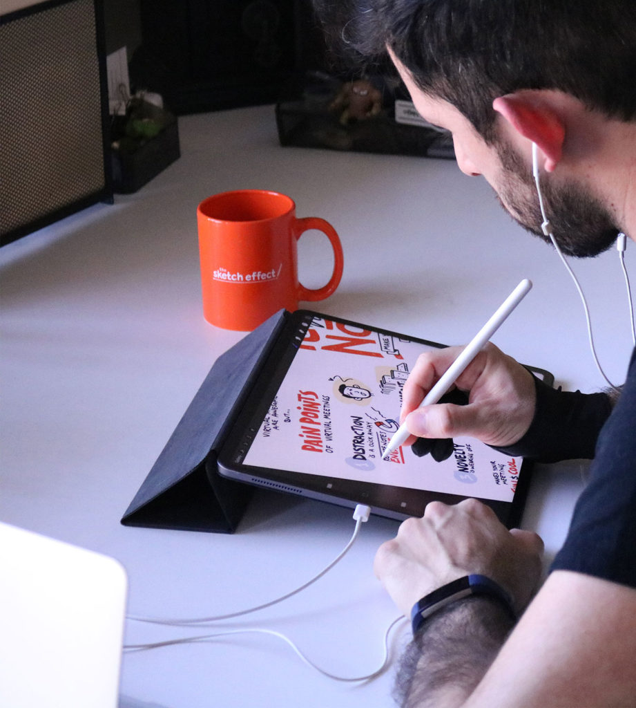 Photograph of graphic recording artist sketching on a tablet during a webinar 