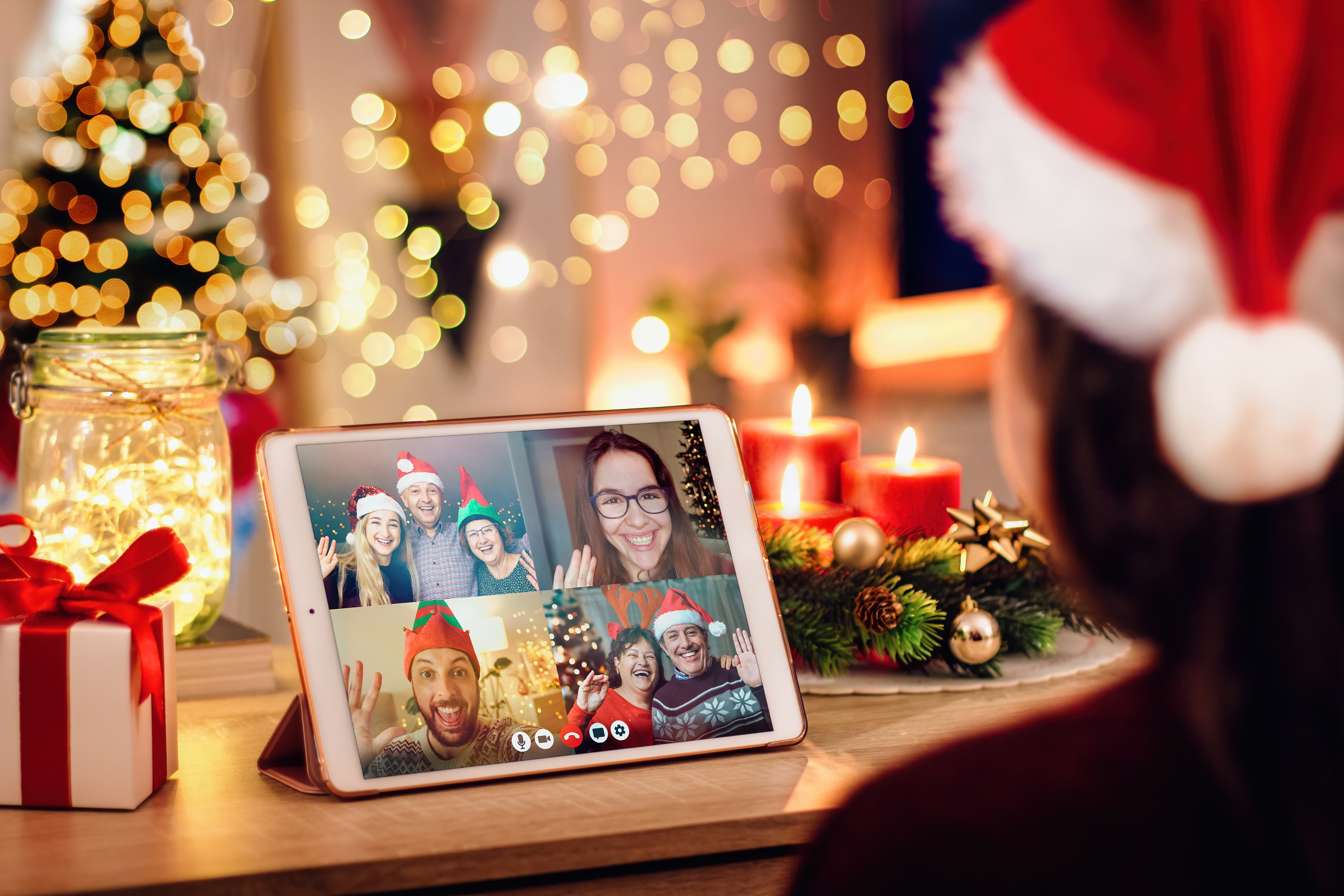 Young woman enjoying a Christmas-themed video call with her happy colleagues.