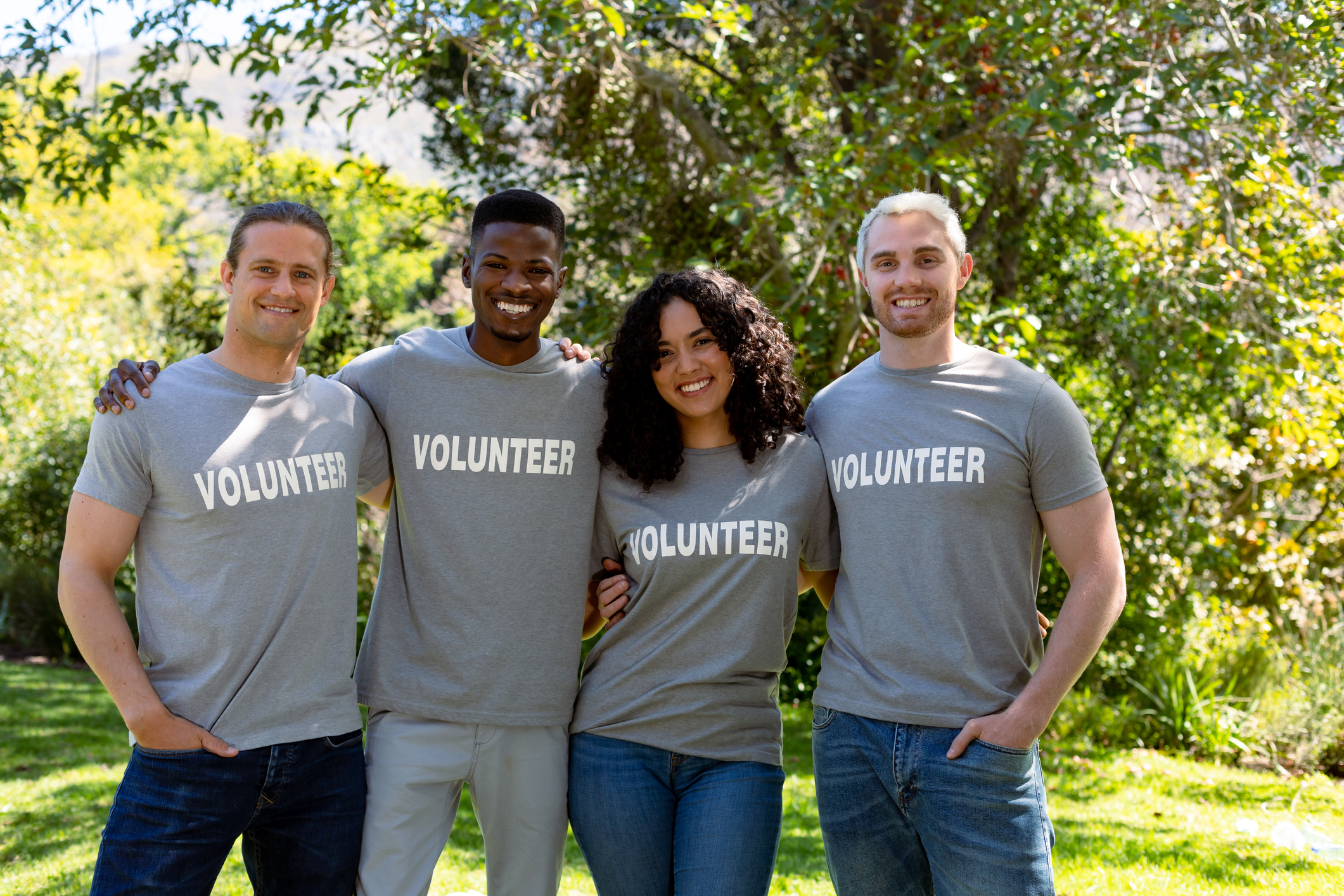Group of smiling volunteers in matching tshirts looking at camera. 